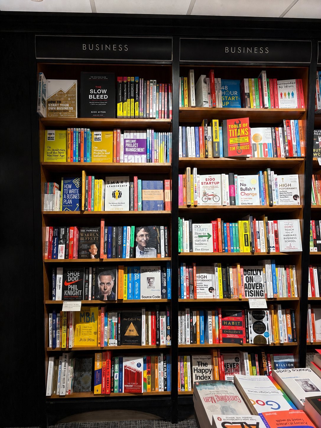 The Slow Bleed on the business bookshelf alongside Tim Ferriss, Phil Knight, Warren Buffett